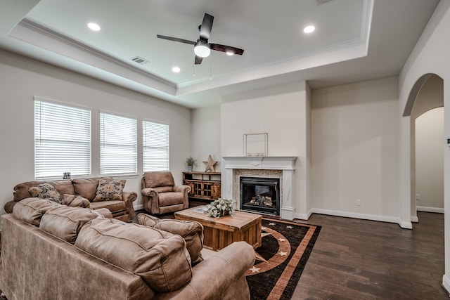 living room with ceiling fan, dark hardwood / wood-style floors, and a tray ceiling