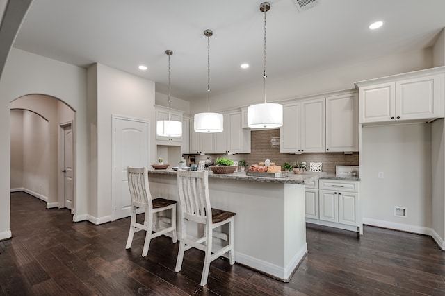 kitchen featuring white cabinetry, hanging light fixtures, backsplash, and dark hardwood / wood-style flooring