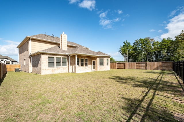 back of house with a lawn and central AC unit