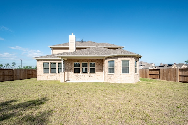 rear view of property featuring a lawn