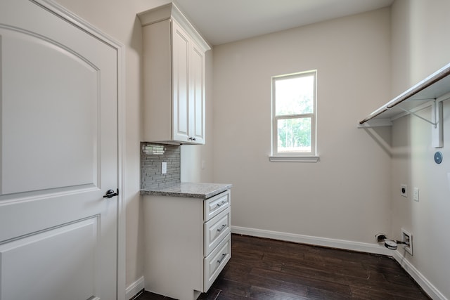 laundry area featuring dark hardwood / wood-style flooring, electric dryer hookup, and cabinets