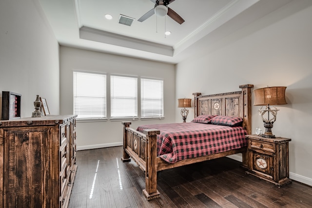 bedroom featuring a raised ceiling, dark hardwood / wood-style floors, ornamental molding, and ceiling fan