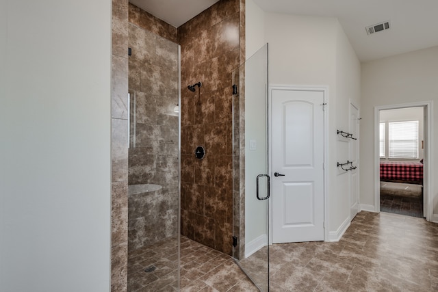 bathroom featuring a shower with shower door and tile flooring