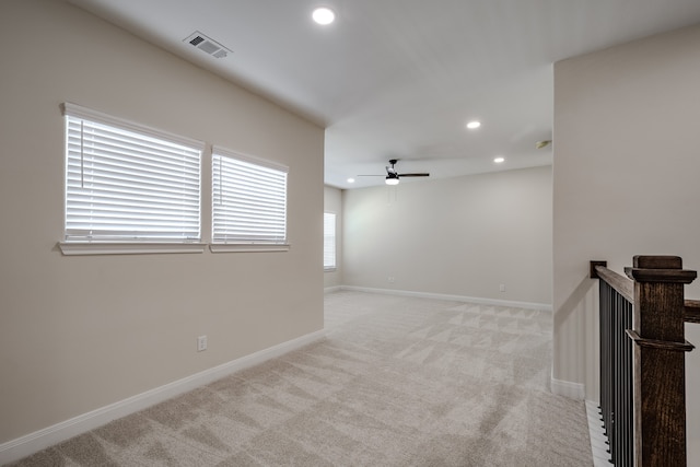 spare room featuring ceiling fan and light colored carpet