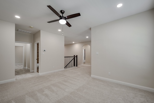 spare room with ceiling fan and light carpet