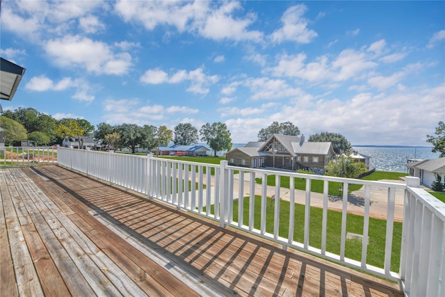 wooden deck featuring a water view and a lawn