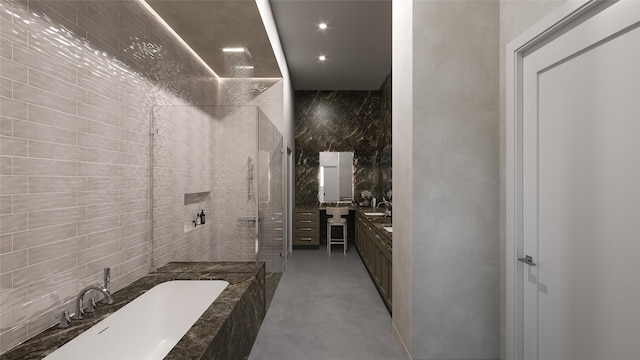 bathroom with vanity, tile walls, a bathtub, and tiled shower