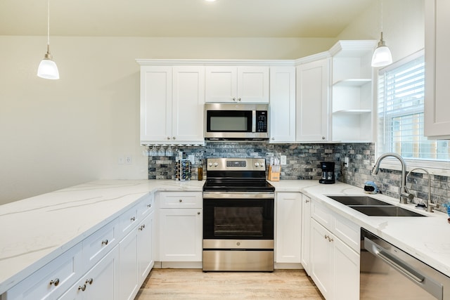 kitchen with white cabinets, hanging light fixtures, and stainless steel appliances