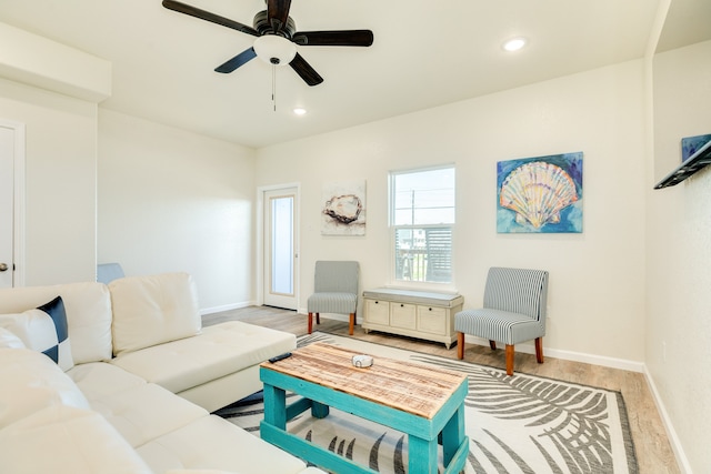 living room with ceiling fan and light hardwood / wood-style flooring