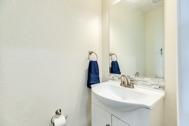 bathroom featuring tasteful backsplash and vanity with extensive cabinet space