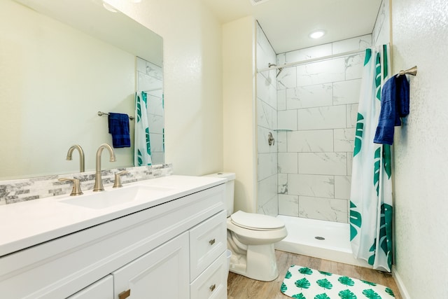 bathroom with walk in shower, toilet, wood-type flooring, and vanity with extensive cabinet space