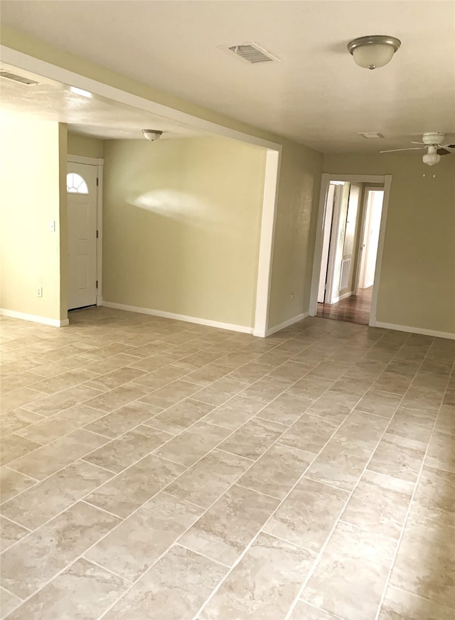 tiled spare room with ceiling fan