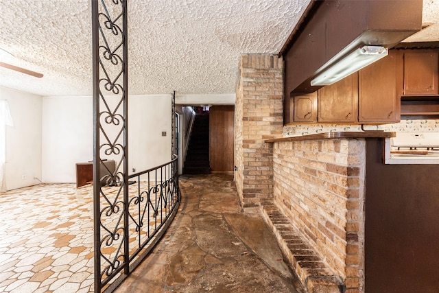 interior space with brick wall and a textured ceiling