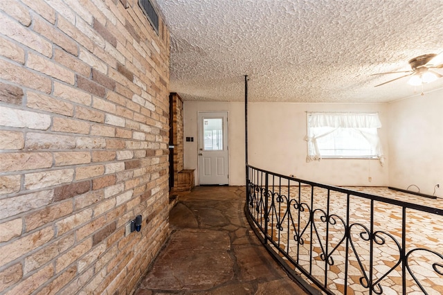 hall featuring brick wall and plenty of natural light