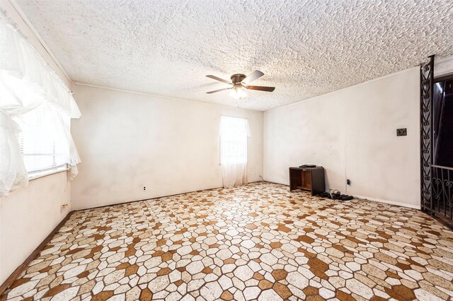 tiled spare room with a healthy amount of sunlight, a textured ceiling, and ceiling fan