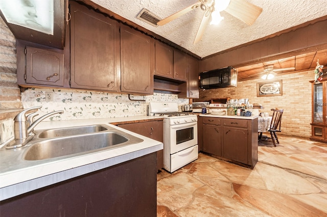 kitchen with white range with gas cooktop, sink, a textured ceiling, brick wall, and ceiling fan