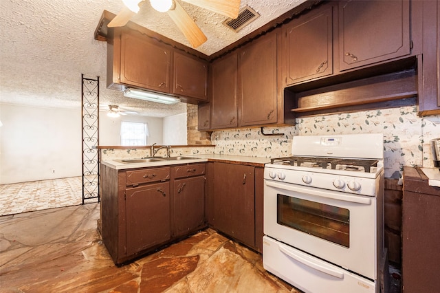 kitchen featuring white range with gas cooktop, sink, premium range hood, a textured ceiling, and ceiling fan