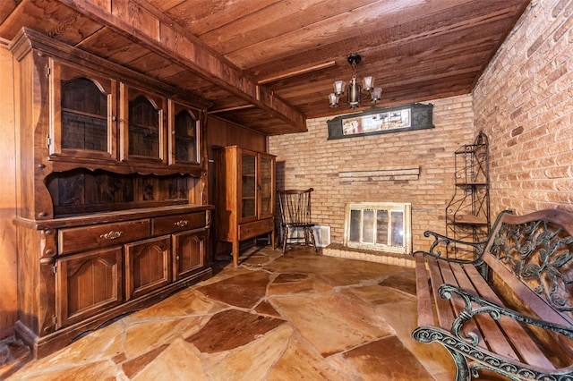 interior space with light tile patterned floors, beamed ceiling, a brick fireplace, brick wall, and wooden ceiling