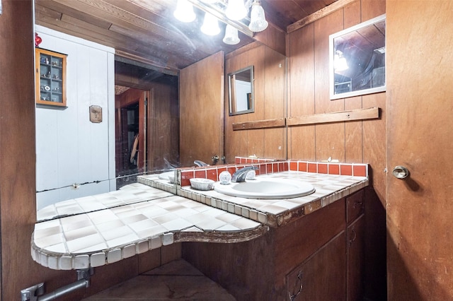 bathroom featuring vanity, wooden ceiling, and wood walls