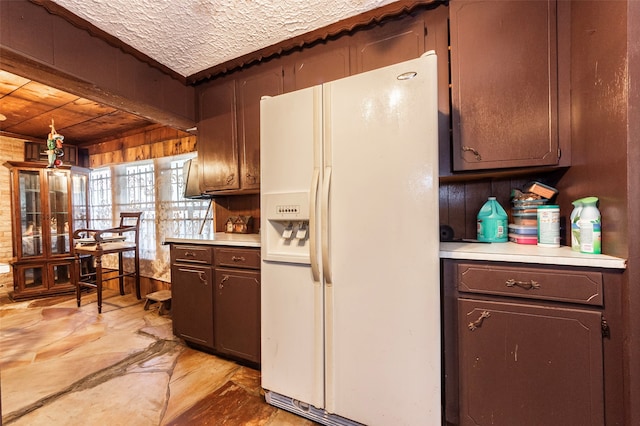 kitchen with white refrigerator with ice dispenser and a textured ceiling