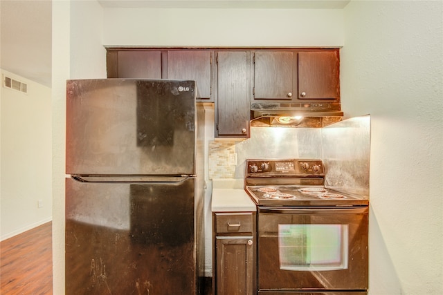 kitchen featuring custom range hood, hardwood / wood-style floors, fridge, backsplash, and black electric range