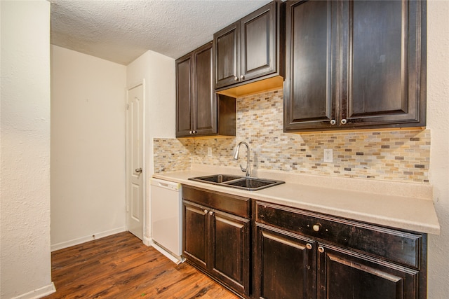 kitchen featuring backsplash, sink, white dishwasher, dark brown cabinets, and dark hardwood / wood-style flooring