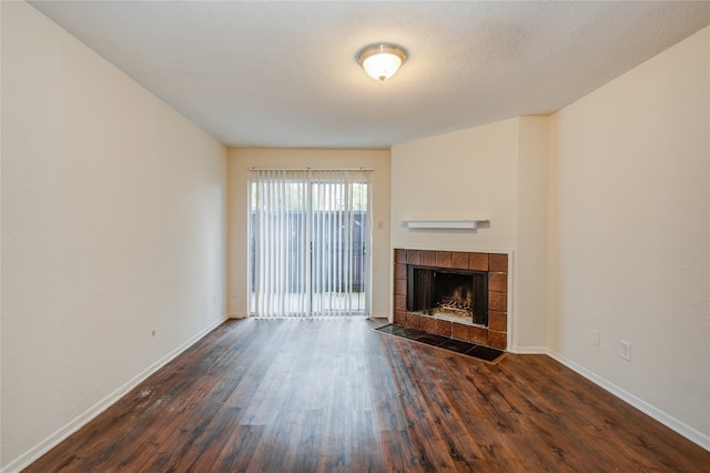 unfurnished living room with a tile fireplace and dark hardwood / wood-style flooring