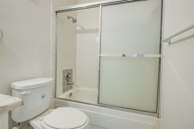 bathroom with enclosed tub / shower combo and toilet