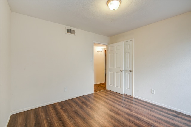 spare room with dark wood-type flooring