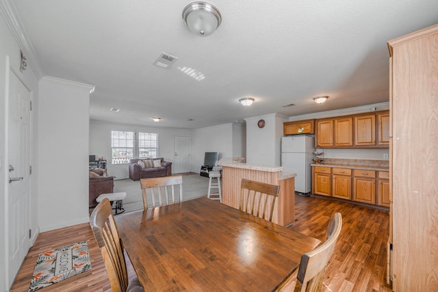 dining space featuring dark hardwood / wood-style floors and crown molding