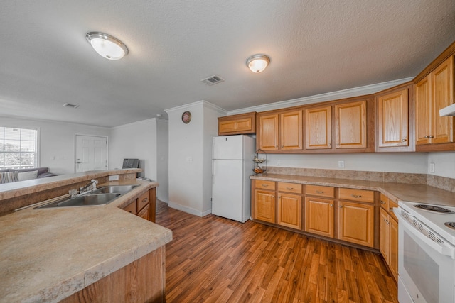 kitchen featuring white appliances, sink, hardwood / wood-style flooring, and ornamental molding