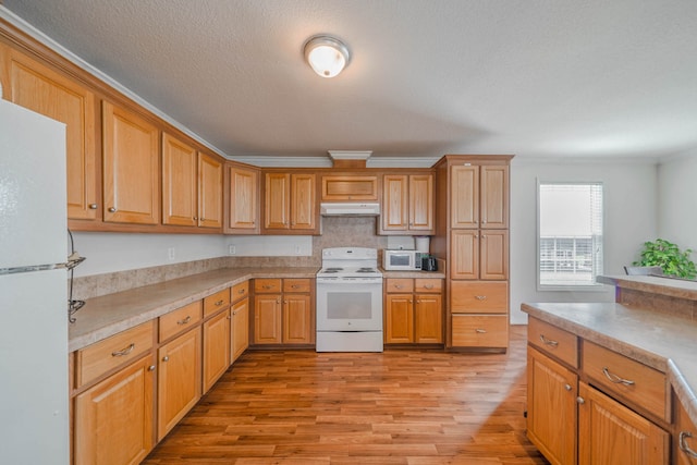 kitchen featuring white appliances, crown molding, and light wood-type flooring