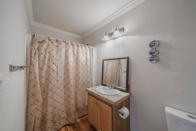 bathroom featuring crown molding, toilet, large vanity, and hardwood / wood-style floors