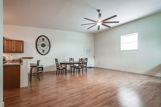 dining space featuring light wood-type flooring, ceiling fan, and baseboards