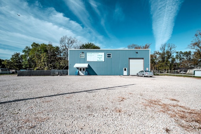 view of outdoor structure featuring a garage, fence, and an outdoor structure