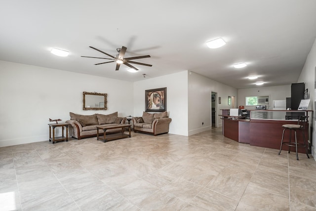 living room featuring ceiling fan and baseboards