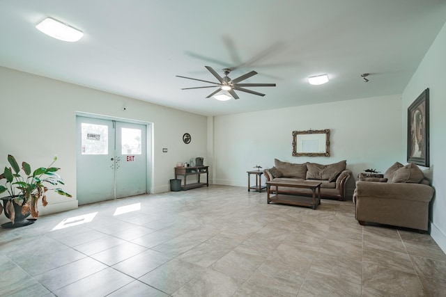 living area with a ceiling fan and french doors