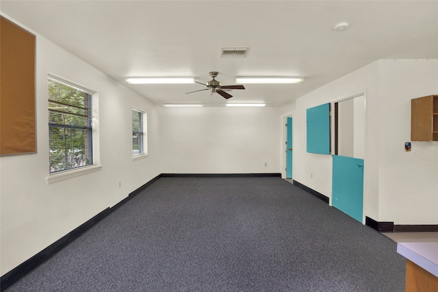 carpeted spare room featuring visible vents, baseboards, and ceiling fan