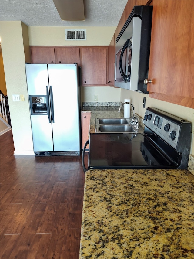 kitchen featuring stainless steel appliances, a textured ceiling, sink, and dark hardwood / wood-style flooring