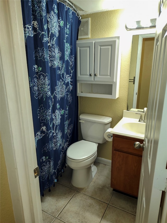 bathroom featuring toilet, tile floors, and vanity