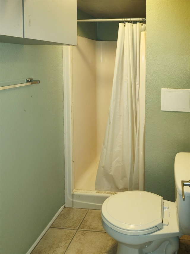 bathroom with tile flooring, a shower with shower curtain, and toilet