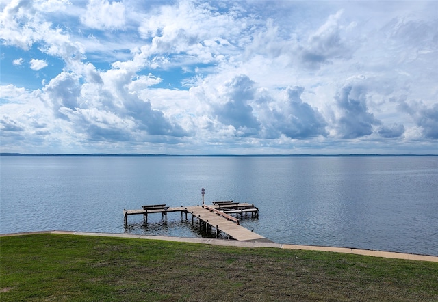 view of dock featuring a water view and a yard