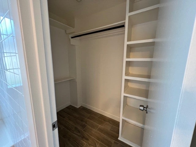 spacious closet with dark wood-type flooring