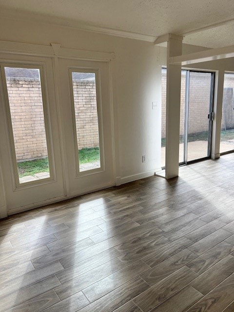 empty room with light hardwood / wood-style flooring and a textured ceiling