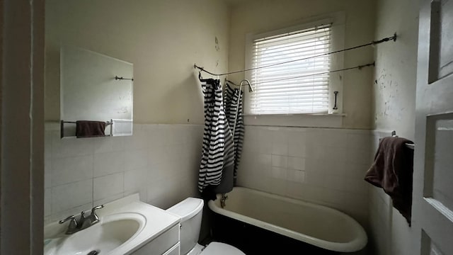 bathroom featuring vanity, tile walls, and toilet