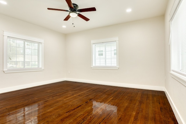 unfurnished room with plenty of natural light, dark wood-type flooring, and ceiling fan