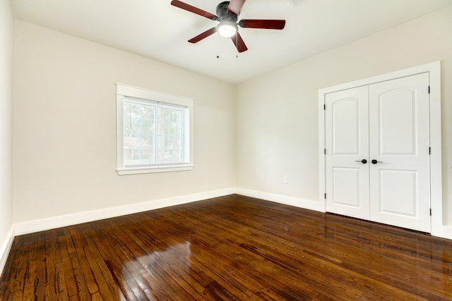 empty room with dark wood-type flooring and ceiling fan