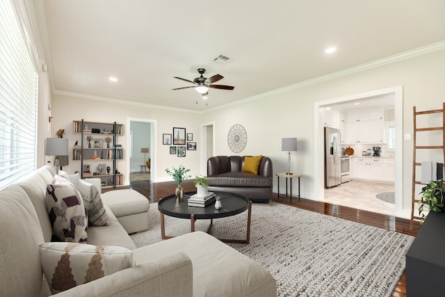 tiled living room with ceiling fan and ornamental molding