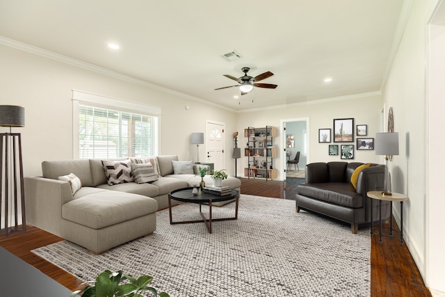 living room with crown molding, ceiling fan, and dark wood-type flooring