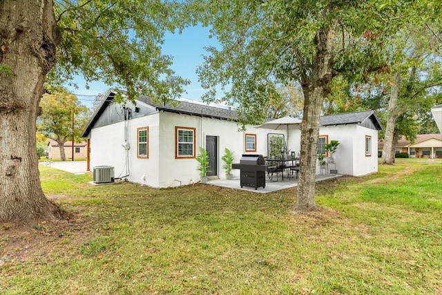 rear view of property with a lawn, a patio area, and central AC unit